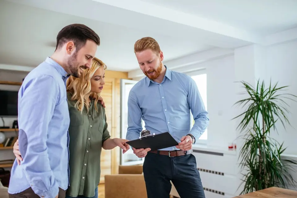 An inspector going over his findings with a couple in their new home